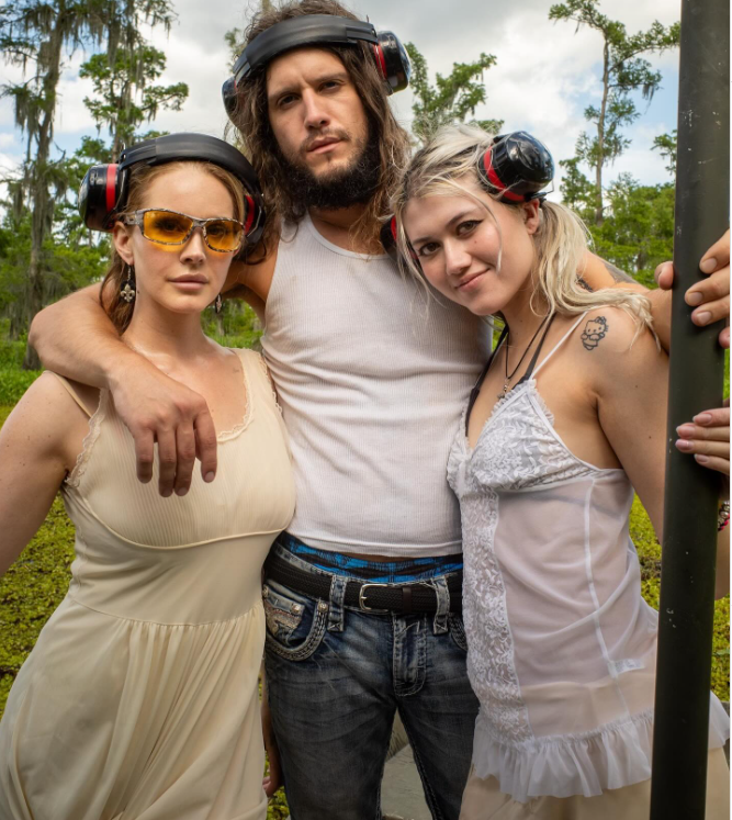 Lana Del Rey posing with a friend and Jeremy Dufrene while on an alligator tour with the guide