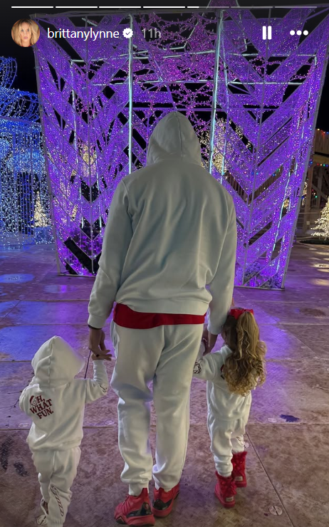 Patrick Mahomes holding the hands of his two infant children at a skating rink